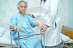 Asian nurse physiotherapist doctor care, help and support elderly old woman patient with walker.