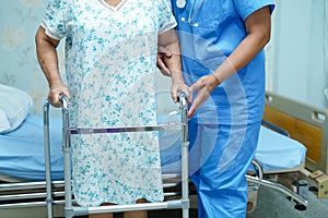 Asian nurse physiotherapist doctor care, help and support elderly old woman patient with walker.