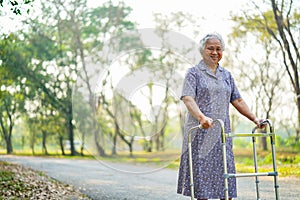 Asian nurse physiotherapist doctor care, help and support senior or elderly old lady woman patient walk with walker at hospital.