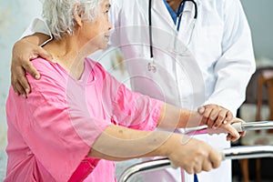 Asian nurse physiotherapist doctor care, help and support senior or elderly old lady woman patient walk with walker at hospital