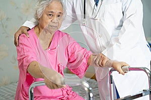 Asian nurse physiotherapist doctor care, help and support senior or elderly old lady woman patient walk with walker at hospital