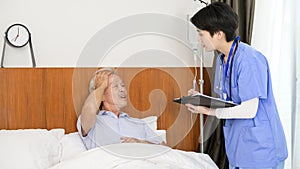 Asian nurse taking care of an elderly man lying on patient bed at  senior healthcare center