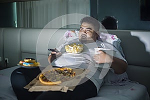 Asian obese man eating junk foods before sleep