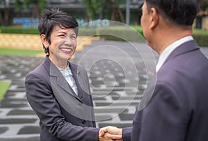 Asian old businesswoman shake hands with her customer