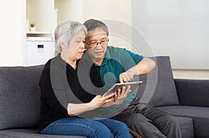 Asian old couple using tablet together