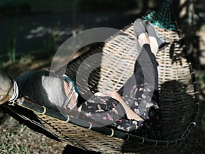 Asian old elderly elder woman wearing mask lying on hammock in garden. senior leisure lifestyle