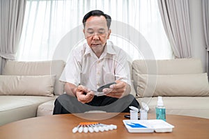 Asian old man check a sugar level in his blood by him self