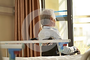 Asian old man sitting in wheel chair in nursing home