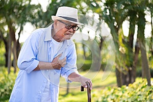 Asian old man walking in park and having a with pain on heart, heart attack. Senior healthcare concept