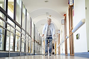 Asian old man walking with a walker in nursing home