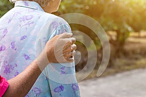 Asian old woman standing with her hands on a walker with daughter& x27;s hand,Hand of old woman holding a staff cane for helping