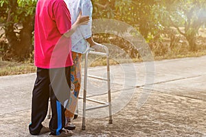 Asian old woman standing with her hands on a walker with daughter& x27;s hand,Hand of old woman holding a staff cane for helping