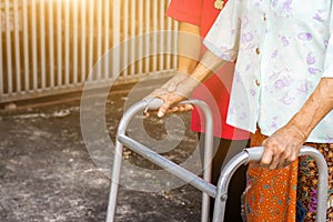 Asian old woman standing with her hands on a walker with daughter& x27;s hand,Hand of old woman holding a staff cane for helping