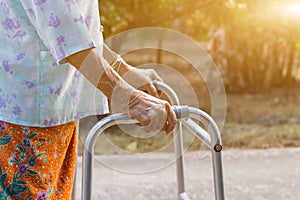 Asian old woman standing with her hands on a walker,Hand of old woman holding a staff cane for helping walking