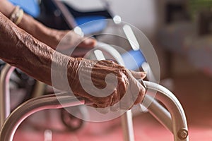 Asian old woman standing with her hands on a walker stand,Hand o