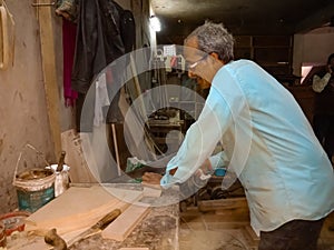 an asian old worker making furniture at sawmill in India January 2020