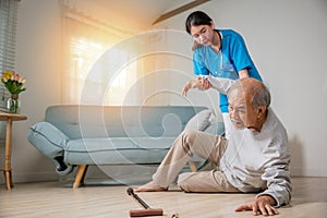 Asian older senior man falling down on lying floor and woman nurse came to help
