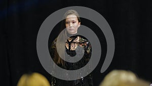 Asian origin woman model walks on podium. Female fashion trendy runway defile.