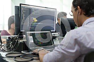 Asian Outsource Developer Looking Screen Sitting At Desk Working photo