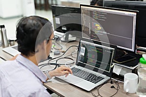 Asian Outsource Software Developer Looking Screen Sitting At Desk photo