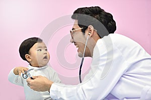 Asian paediatrician examining a baby with a stethoscope