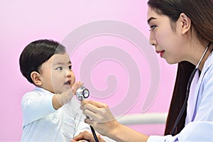 Asian paediatrician examining a baby with a stethoscope photo