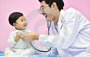 Asian paediatrician examining a baby with a stethoscope