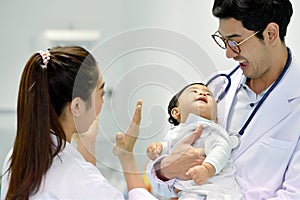 Asian paediatrician is taking care of baby