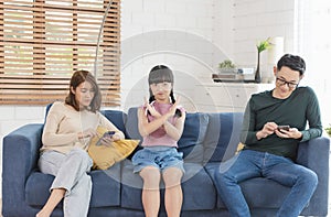 Asian parent using tablet and mobile phones at home. addicted to devices, gadgets dependence overuse