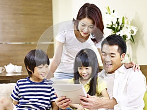 Asian family with two children using digital tablet together
