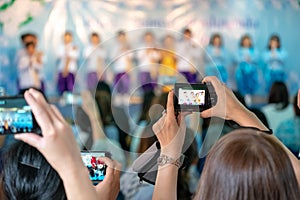 Asian parents recording vdo and photo shooting in their kids school event, Bangkok, Thailand