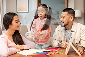 Asian Parents Teaching Daughter To Read, Playing With Letters Indoor