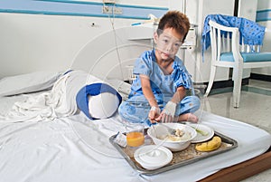 Asian patient boy with saline intravenous (iv) on hospital bed.