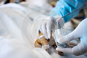 Asian patient`s hand with an attached pulse oximeter on finger for monitoring,doctor measuring pulse rate and oxygen saturation,