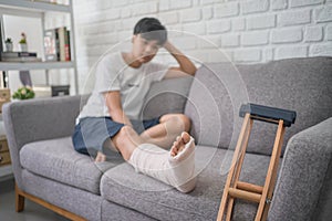 Asian people with broken leg recovering at home