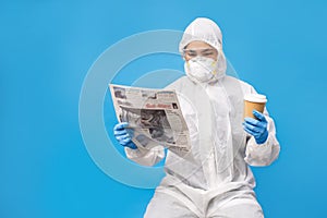 Asian people in protective clothing complete with gloves and masks. She is reading a newspaper and hot coffee in the studio on a