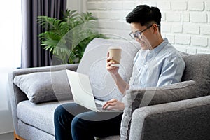 Asian people work in laptops on the sofa at home