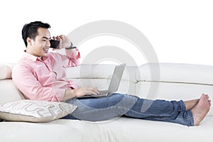 Asian person with laptop on couch