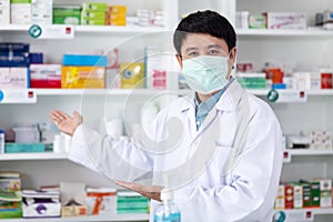 Asian pharmacist man wearing a mask protective COVID-19 and happy to Service in drugstore