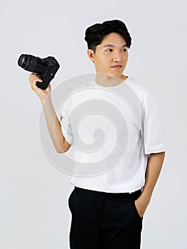 Asian photographer looking outside while standing in a white photography scene. The atmosphere in the photo studio
