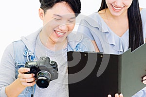 Asian Photographer and model looking pictures from camera