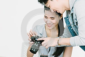 Asian Photographer and model looking pictures from back screen of camera