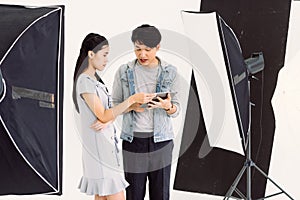 Asian Photographer and model looking pictures from tablet