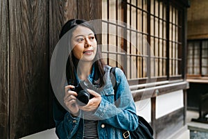 Asian photographer relying on the wooden wall