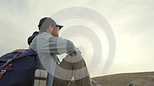 Asian photographer sitting on ground looking at view