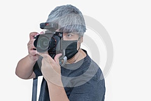 Asian photographer wearing a mask to protect against Covid. Photo taken  on white background.