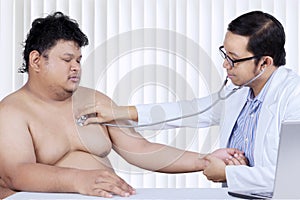 Asian physician checks heartbeat of his patient