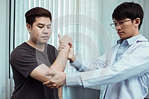 Asian physiotherapists check the elbows of patients who have undergone orthopedic rehabilitation photo