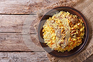 Asian pilaf on a brown plate. horizontal top view, rustic
