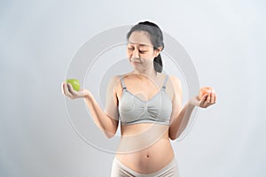 Asian pregnant woman eating fruit for her and infant healthy